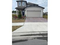 Two-story home featuring a two-car garage, landscaped yard, and a welcoming front entry at 144 Links Terrace, Daytona Beach, FL 32124