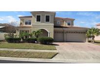 Spacious two story home featuring a three-car garage and landscaped front yard at 2802 Quiet Water Trl, Kissimmee, FL 34744