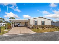 Single-wide manufactured home with covered patio and landscaped yard at 108 Dogwood Trl, Leesburg, FL 34748