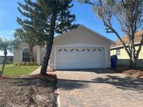 Charming single-story home features a two-car garage and a well-maintained brick driveway at 2410 Shelby Cir, Kissimmee, FL 34743