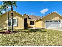 Charming single-story home featuring a well-manicured lawn and a two-car garage at 434 Acacia Tree Way, Kissimmee, FL 34758