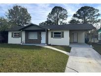 Newly renovated single story home with carport and well-manicured lawn at 5218 Lescot Ln, Orlando, FL 32811