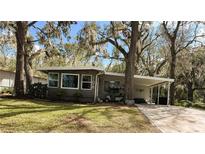Charming single story home featuring mature landscaping and a convenient covered parking area at 106 Royal Palm Dr, Leesburg, FL 34748
