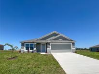 Charming single-story home featuring a gray exterior, stone accents, and a well-manicured lawn at 1212 Caloosa Ridge Ave, Babson Park, FL 33827