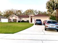 Charming single-story home with well-manicured lawn, concrete drive, and mature landscaping at 3201 Fairhaven Ave, Kissimmee, FL 34746