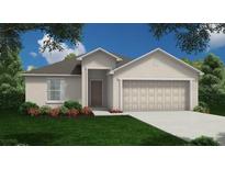 Charming single-story home featuring a two-car garage and well-manicured landscaping at 134 W 7Th St, Frostproof, FL 33843