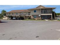 Beige two-story condo with covered parking and screened porch at 1640 Juno Trl # 101A, Astor, FL 32102