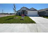 New single-story home with a two-car garage, manicured lawn, and decorative stone accents at 2117 Lincoln Ln, Bartow, FL 33830