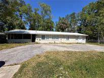 Charming single-story home with a metal roof and large front yard at 24047 Ermine Rd, Astor, FL 32102