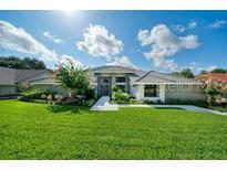 Charming single-story home featuring mature landscaping, fresh green lawn, and walkway leading to the front door at 365 N Spaulding Cv, Lake Mary, FL 32746