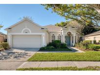 Charming one-story home with manicured lawn, lush landscaping, and a two-car garage at 9651 Old Marsh Ct, Orlando, FL 32832