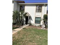 Charming townhouse featuring an inviting entrance, well-maintained lawn, and lush palm trees at 1104 Illinois Ave, St Cloud, FL 34769