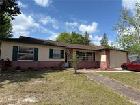 Charming single-story home with a brick facade, green shutters, and a well-maintained front yard at 120 Borada Rd, Sanford, FL 32773
