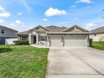 Charming single-story home featuring a three-car garage and inviting front lawn at 1936 Bell Creek Loop, Fruitland Park, FL 34731