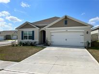 Charming single-Gathering home featuring a two-car garage and well-maintained front yard at 2688 Magnolia Ave, Davenport, FL 33837