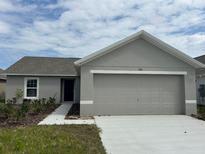 Single story home featuring a well-manicured lawn and attached two car garage at 280 Harper Estates Cir, Lake Wales, FL 33859