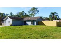 Charming single-story home featuring a spacious front yard with lush grass and a newly installed wooden fence at 3426 Somerset Ave, Deltona, FL 32738