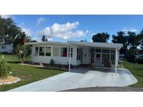 Attractive home with covered parking, pristine landscaping, and charming curb appeal at 102 Tangelo Cv, Leesburg, FL 34748