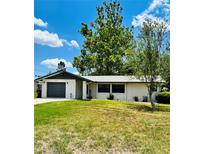 Charming single-story home featuring a well-maintained lawn, garage, and serene landscaping at 10529 Se 50Th Ave, Belleview, FL 34420