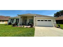 Charming single-story home featuring a well-manicured lawn and a two-car garage at 10640 Vista Del Sol Cir, Clermont, FL 34711