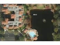 Overhead view of condo complex with a serene lake and a community pool at 12527 Floridays Resort Dr # 406-E, Orlando, FL 32821