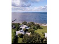 Stunning aerial view of the waterfront property with lush landscaping and private beach access at 12765 Se 143Rd Ave, Ocklawaha, FL 32179
