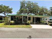 Charming single-story home featuring a covered carport, screened porch, and well-maintained landscaping at 201 Jacaranda Dr, Leesburg, FL 34748