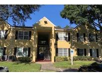 Inviting yellow two-story condo with black shutters and well-maintained landscaping at 2013 Dixie Belle Dr # 2013K, Orlando, FL 32812
