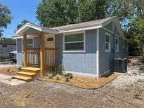 Charming exterior of a light blue home with a small, inviting wooden porch at 2217 Azalea Ct, Lakeland, FL 33815