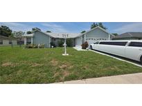 Charming single-story home with well-maintained lawn, landscape accents, and long limousine at 303 Silk Oak Dr, Kissimmee, FL 34743