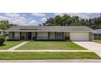 Charming single-story home features a well-manicured lawn, tidy landscaping, and an attached two-car garage at 4514 Crichton Ln, Orlando, FL 32806