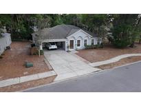 Charming single-story home with an attached carport and well-manicured landscaping at 901 Cascades Park Trl, Deland, FL 32720
