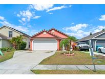 Charming single Gathering home with a well maintained lawn, flowering landscape, and a two car garage at 9668 Hollyhill Dr, Orlando, FL 32824
