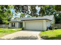Charming single-story home featuring an attached two-car garage and a well-maintained front lawn with mature trees at 1011 Chance Cv, Oviedo, FL 32765