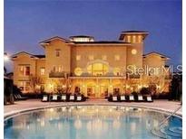 Elegant clubhouse view from a resort-style pool surrounded by lounge chairs at twilight at 1325 Rotonda Pt # 313, Lake Mary, FL 32746