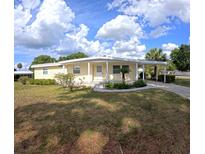Charming single-story home with a covered carport and well-maintained lawn, perfect for relaxed living at 15 Ne 63Rd Ct, Ocala, FL 34470