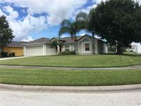 Well-maintained single-story home with a manicured lawn and mature trees at 2470 Augusta Way, Kissimmee, FL 34746