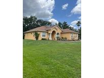 Charming single-story home features a well-manicured lawn and an inviting arched entryway at 2913 Deerbrook Dr, Lakeland, FL 33811
