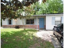 Charming single-story home featuring light-colored siding, light blue shutters, a bright blue door, and a well-maintained front lawn at 360 Kentia Rd, Casselberry, FL 32707
