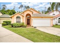 Charming single-story home featuring a well-manicured lawn and attached two-car garage at 615 Maple Forest Dr, Orlando, FL 32825