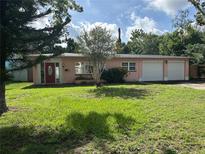 Charming single-story home with a well-manicured lawn and inviting red front door at 907 N Hyer Ave, Orlando, FL 32803