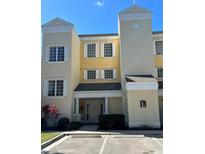 Charming condo featuring a yellow facade, shuttered windows, and a welcoming entrance at 1310 Seven Eagles Ct # 102, Reunion, FL 34747