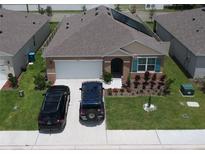 A charming single-Gathering home features solar panels, a two-car garage, and a beautifully landscaped front yard at 3041 Tobago Dr, Haines City, FL 33844