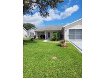 Charming single-story home with well-maintained lawn and landscaping, including an attached one-car garage at 527 San Pedro Dr, The Villages, FL 32159