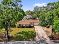 Charming single-story home with a well-manicured lawn and mature trees lining the property at 5806 Fernhill Dr, Orlando, FL 32808