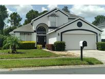 Two-story house with a white exterior, black accents, and a two-car garage at 2863 Picadilly Cir, Kissimmee, FL 34747