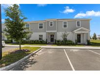 Two-story townhome with gray siding, landscaping, and a paved driveway at 1330 Blazing Star Ln, Davenport, FL 33837