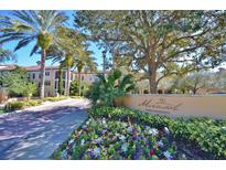 Elegant Mirasol Private Residences entrance with colorful landscaping and palm trees on a sunny day at 500 Mirasol Cir # 105, Celebration, FL 34747