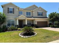 Charming two-story home featuring a well-manicured lawn, attached two car garage, and attractive neutral paint scheme at 1387 Lexington Ave, Davenport, FL 33837