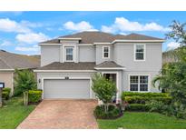 Charming two-story home featuring a brick driveway, attached garage, and manicured landscaping at 3241 Wauseon Dr, Saint Cloud, FL 34772